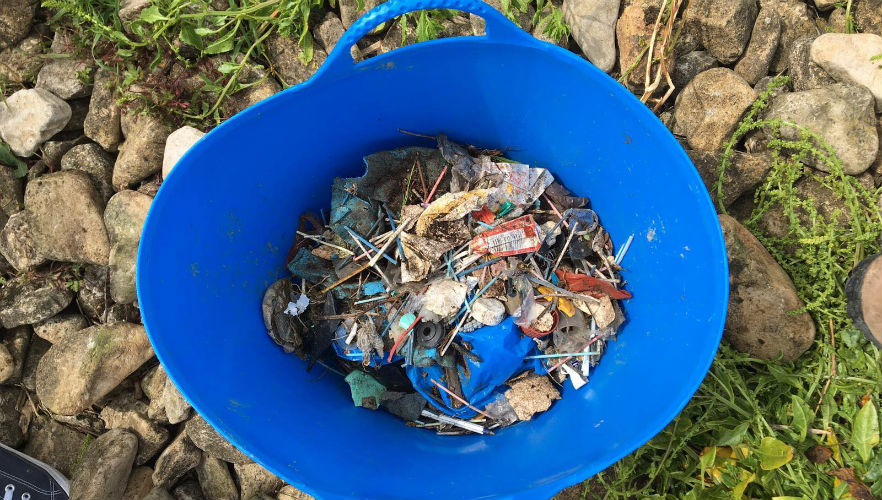 Blue bucket of things found whilst cleaning the beach 