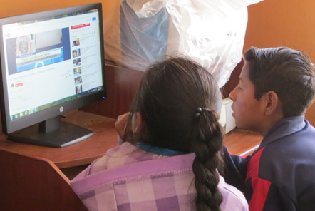 Children looking at computer in Peru