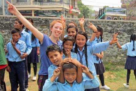 Volunteer with local children at school
