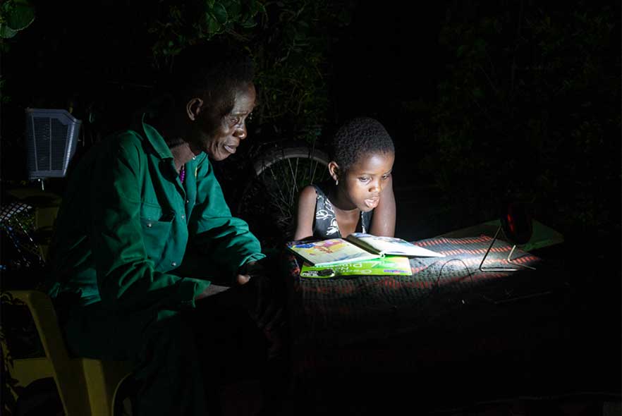 Child in Ghana reading with a parent 