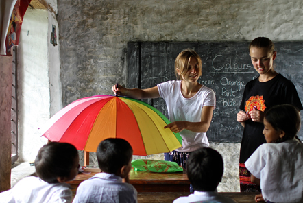 Ladies with multi coloured umbrella in classroom