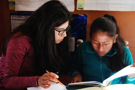 Volunteer lady tutoring a girl 
