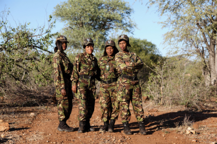 Four rhino volunteers in the woods wearing combat clothes 
