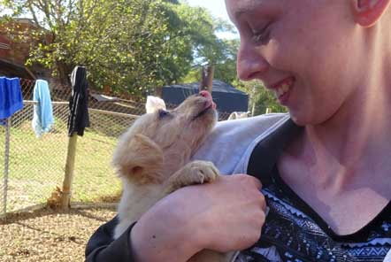 Volunteer holding and smiling at dog