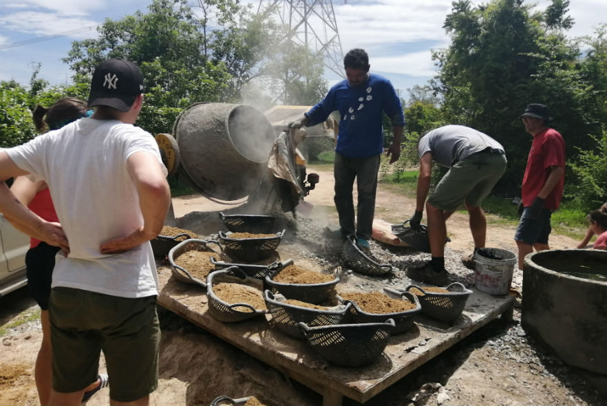 Volunteers working with baskets of sand 