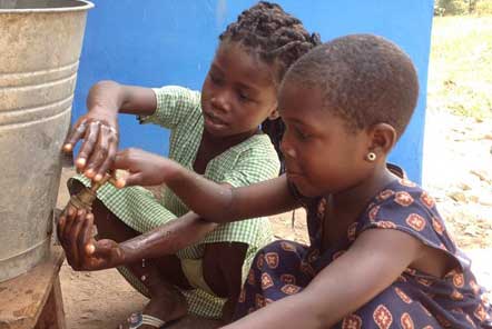 Children getting water from a container tap in Ghana 