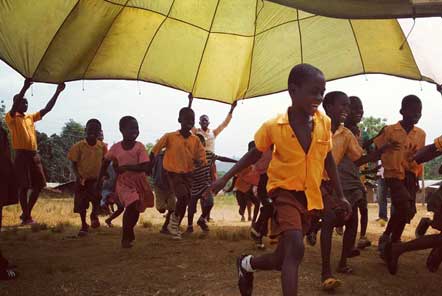 Children flapping yellow fabric material in Ghana