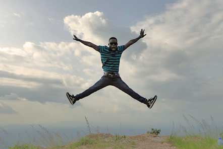 Man jumping up in the air with arms and legs outstretched 