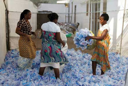 Three ladies sorting plastic bottles into baskets 